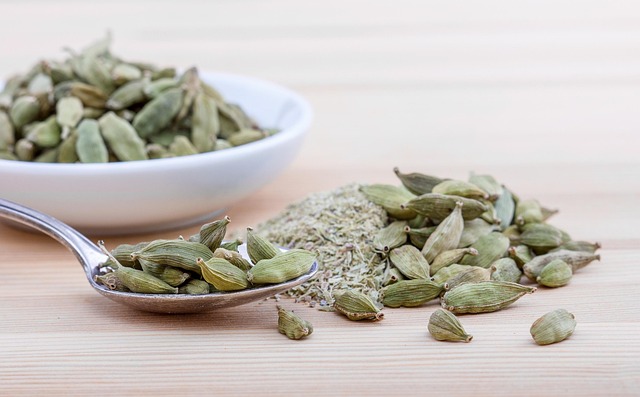 Detailed macro view of whole dried green cardamom pods revealing their papery textured husks with natural vertical striations in various shades of green from light pistachio to rich forest tones